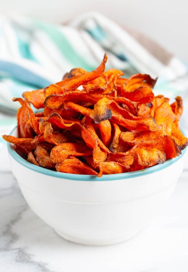 carrot recipes Crispy carrot chips piled high in a bowl.