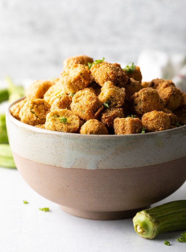 Bowl overflowing with breaded fried okra.