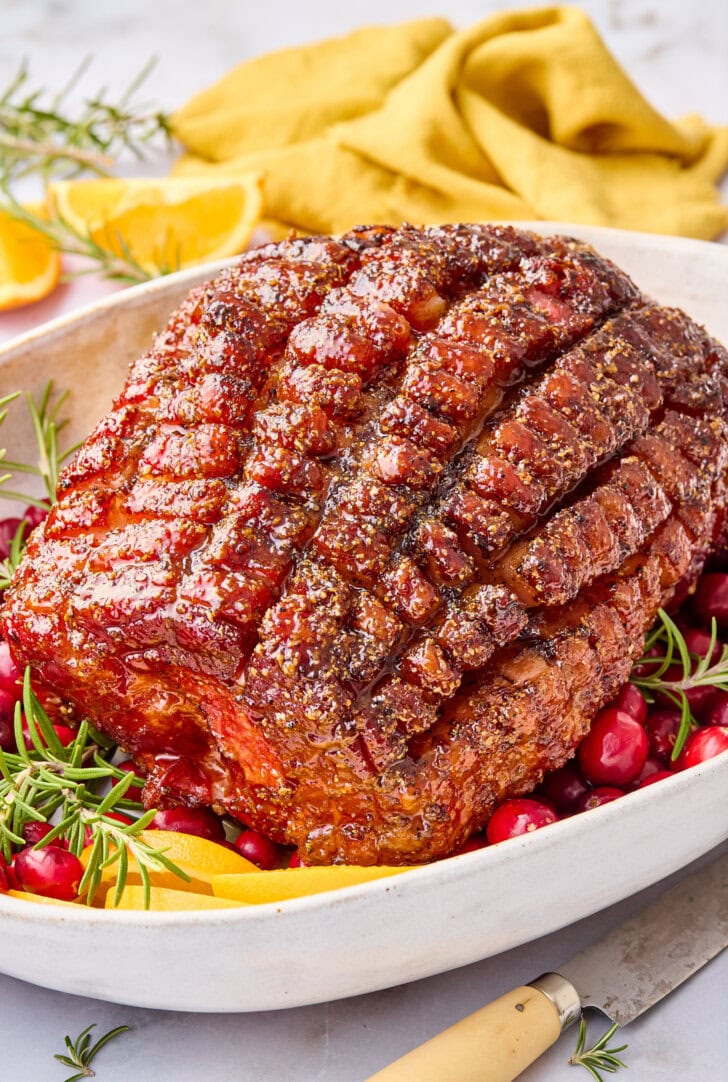 Brown sugar glazed Thanksgiving ham after being baked and served on a platter.