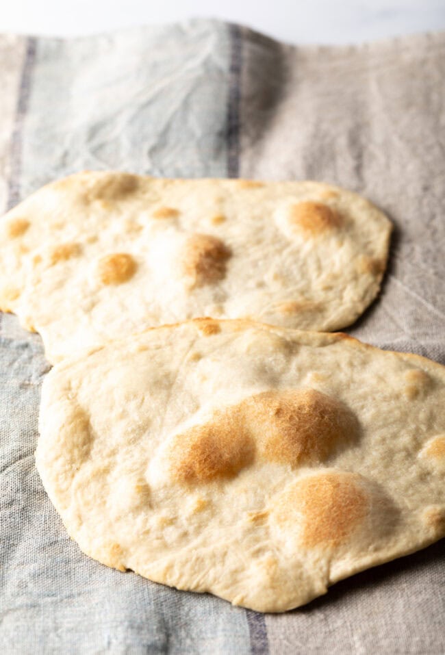 Two pieces of unleavened bread laying on a gray background.