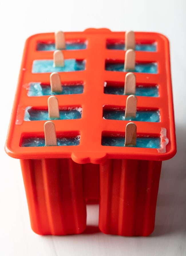 Red popsicle mold with 10 popsicles still in mold.