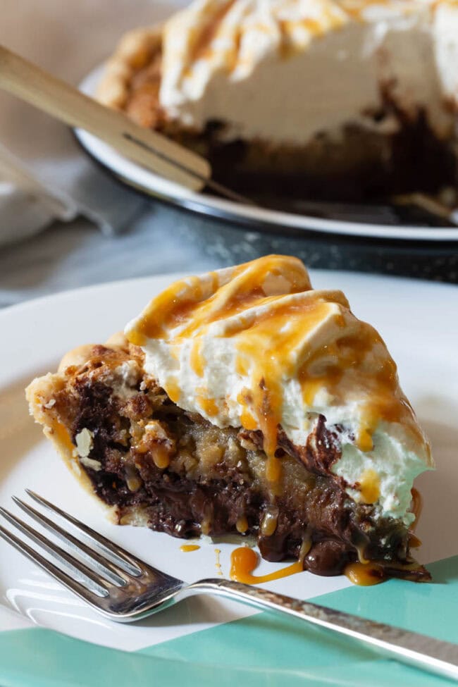 derby-pie A slice of chocolate pecan pie on a white plate with a fork.