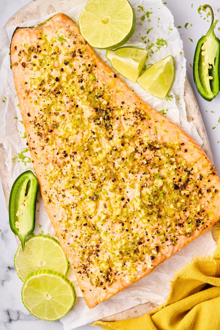 Baked Salmon #ASpicyPerspective #Salmon #BakedSalmon #OvenBakedSalmon #SalmonInTheOven #HowLongtoBakeSalmon #Garlic #Lime #Jalapeno #SpicySalmon #Dinner #Fish Overhead shot of oven baked salmon with lime and jalapeño.