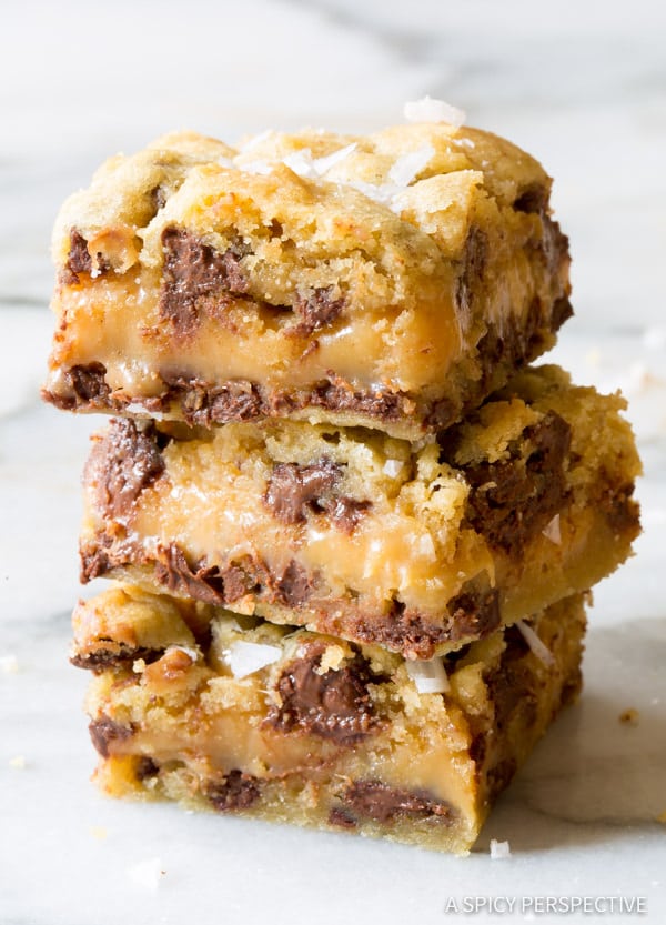 Amazing Salted Caramel Chocolate Chip Cookie Bars, with gooey caramel centers. This cookie bar recipe is so delicious, everyone will ask for the recipe. #ASpicyPerspective #cookiebars #cookies #chocolatechip #baking #dessert